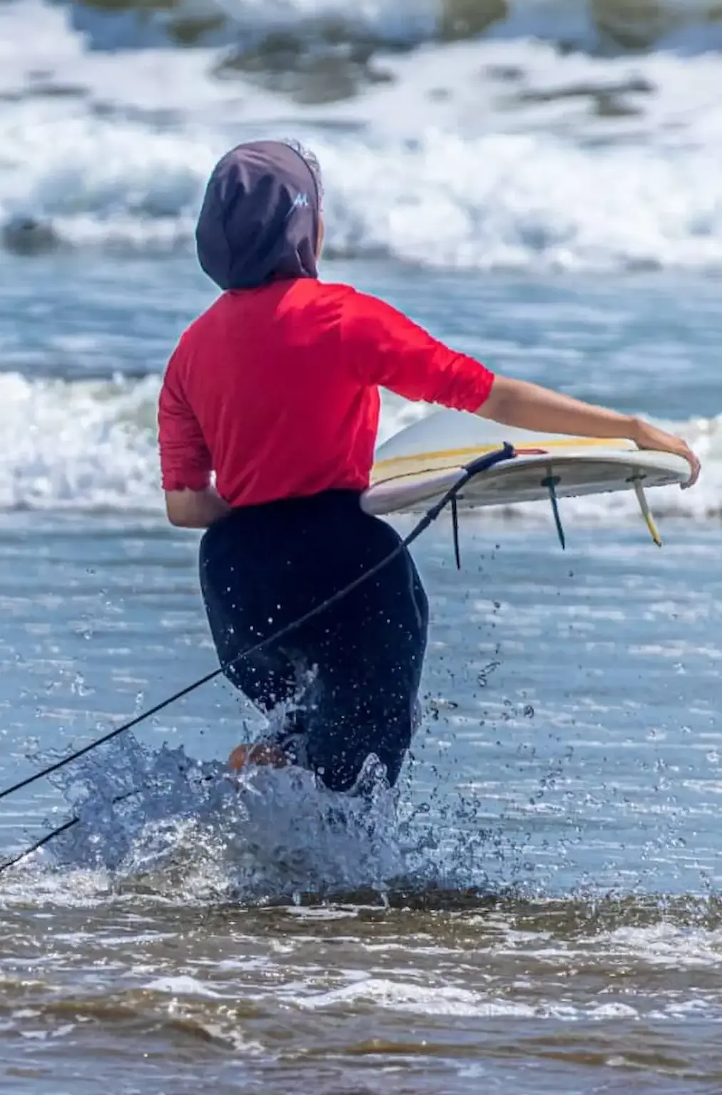 دختر موج‌سوار باشگاه رمین در حال ورود به آب