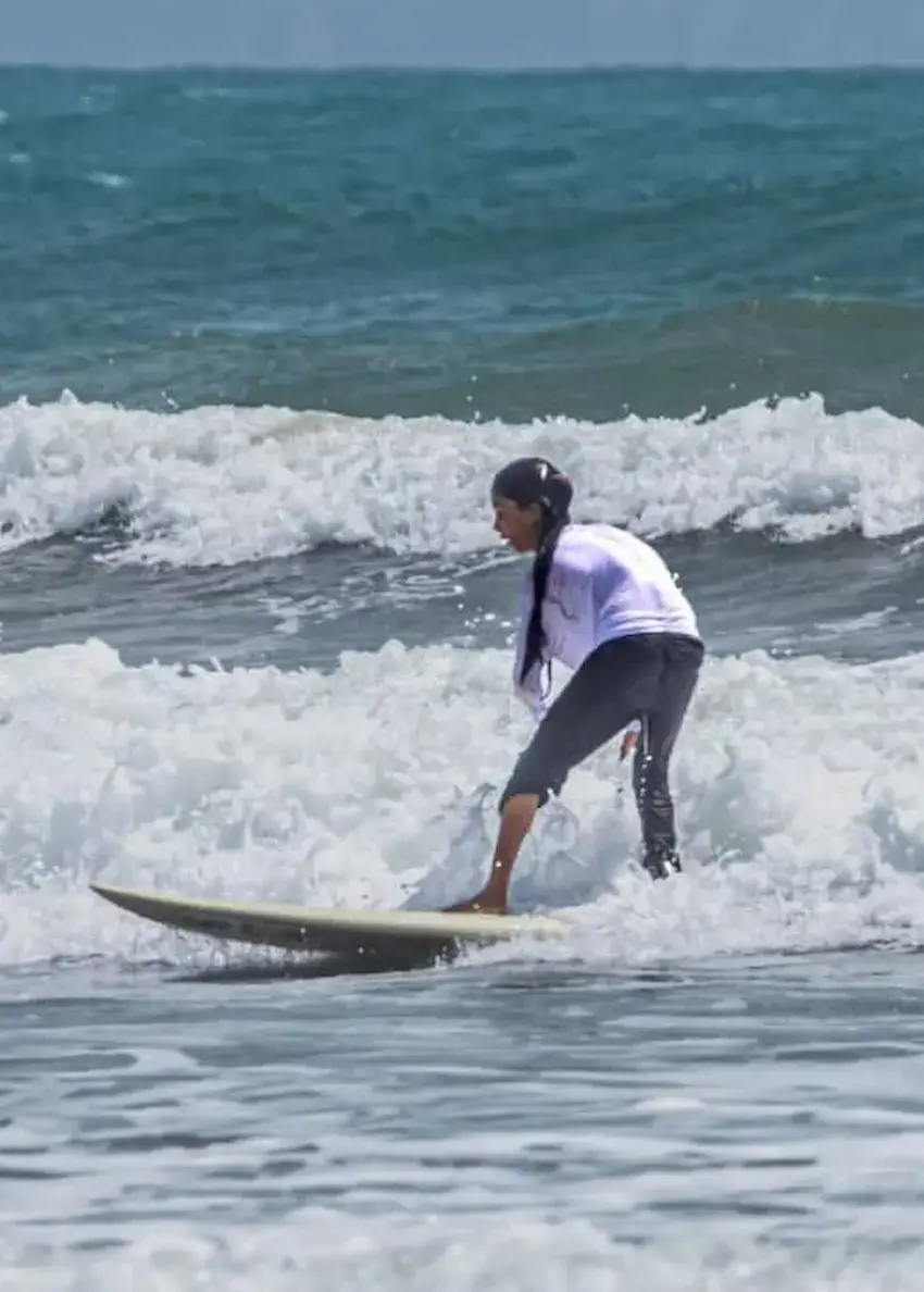 دختر نوجوان موج‌سوار باشگاه رمین در حال آموزش زیر نظر مربی